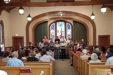 Men's group singing in a church sanctuary