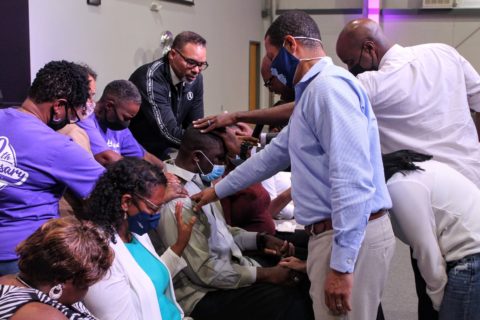 Elders lay hands on someone for prayer
