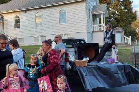 Families dress up for Halloween and pass out candy outside their cars
