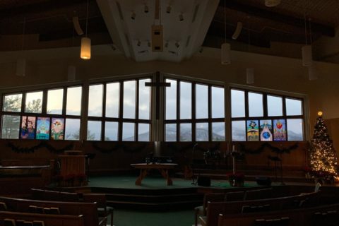 Empty church room with large window overlooking the mountains