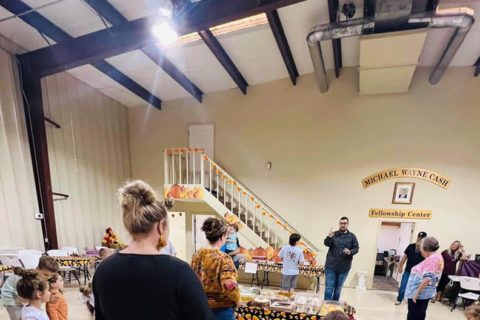 Children and adults playing games in a gym for a fall festival