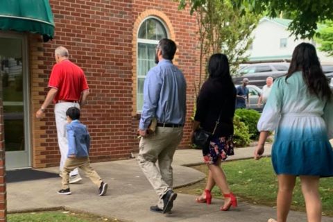 Families walk into a church building