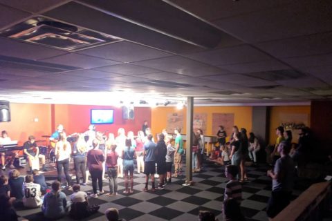 large group of kids in a big fellowship hall with a black and white checkered floor