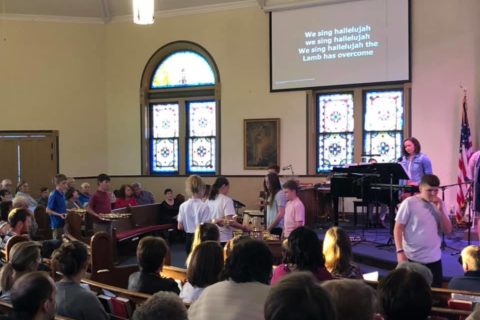 Youth serve communion in a traditional church service
