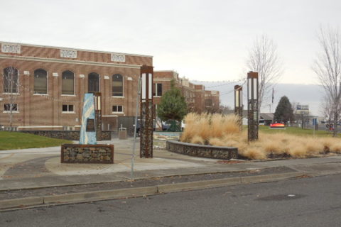 A court yard with a beige brick building in the background